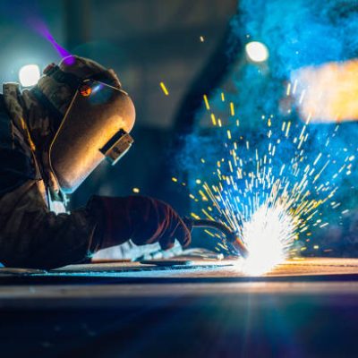 Industrial Welder With Torch in big hall welding metal profiles