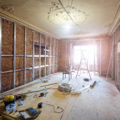 Construction materials, tools and installed frames for plasterboard for making gypsum walls on the brick wall in in apartment that is under construction, remodeling, renovation, overhaul, extension, restoration and reconstruction