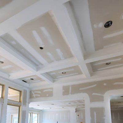 Ceiling with coffered design is in progress, drywall work lighting fixtures in new home.