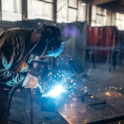 Men welding metal in workshop