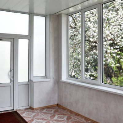 Metal-plastic doors and windows in the loggia. View interior from the middle, outside blossom apple